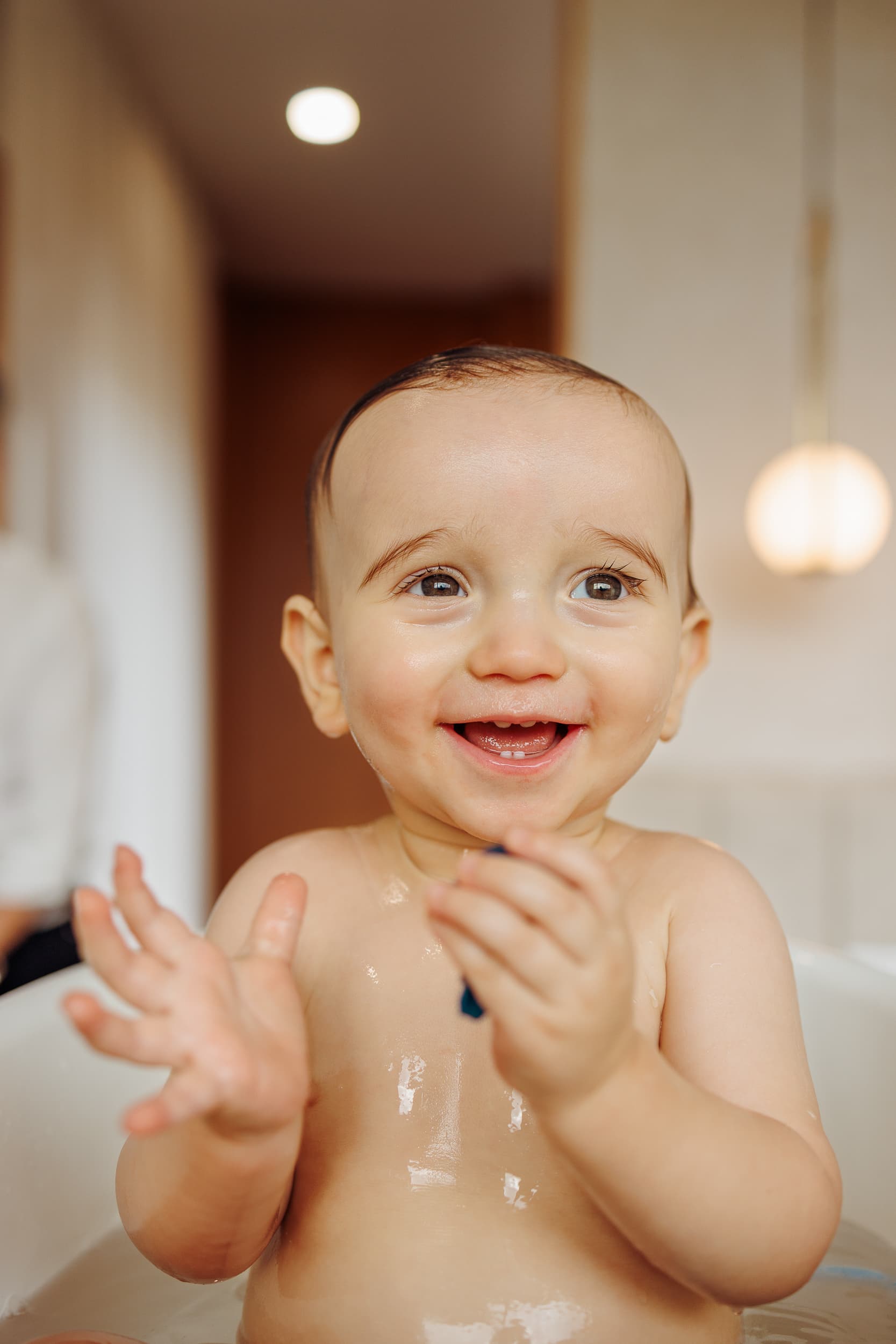 Bebé sorridente na banheira durante uma sessão fotográfica de pré-batizado